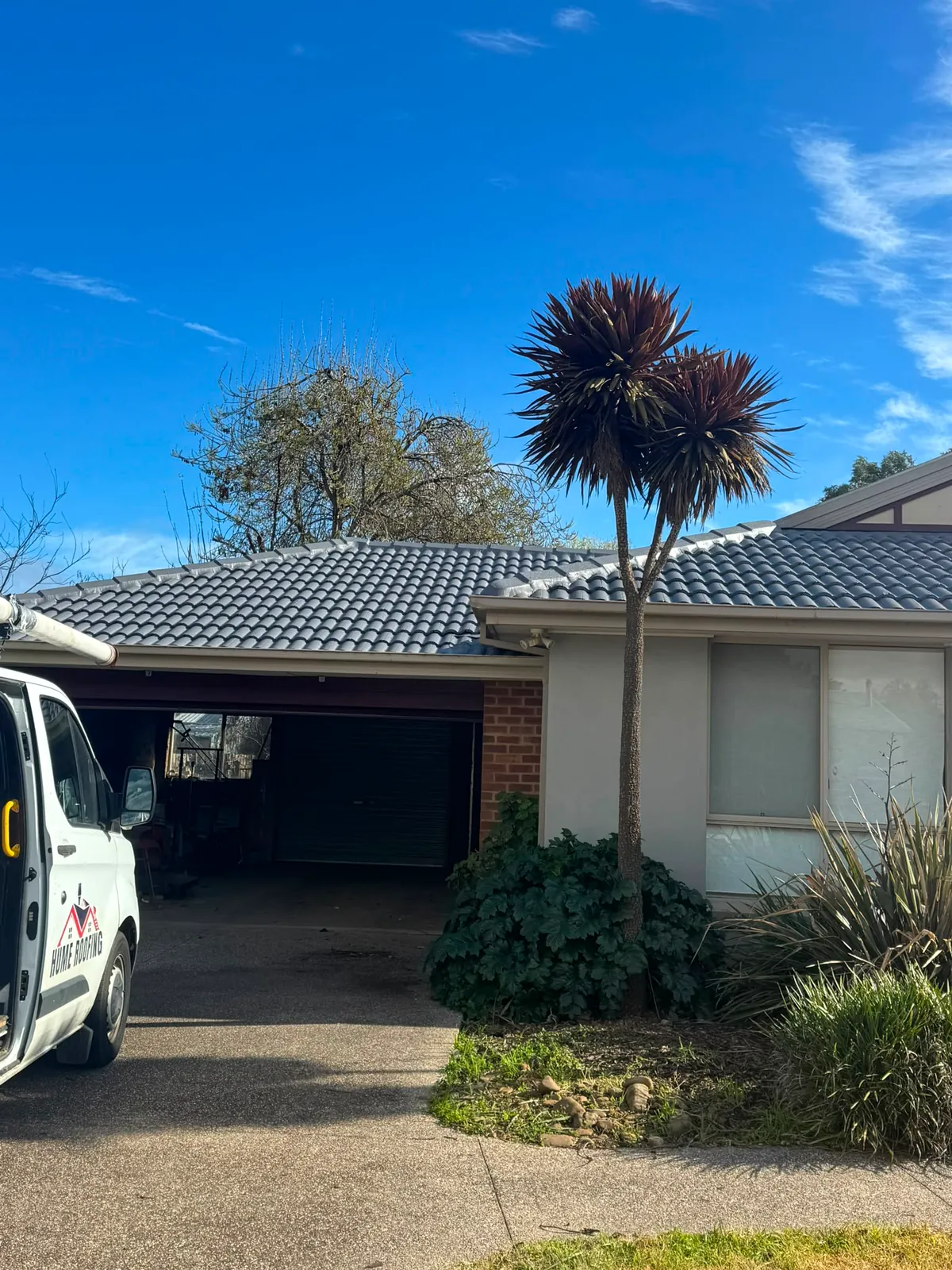 Completed grey tile roof restoration with Hume Roofing vehicle
